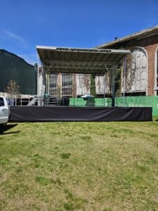 A truck parked in front of an outdoor stage.