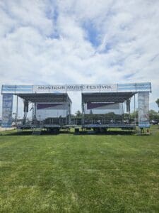 A stage set up in the grass for an outdoor event.