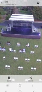 A view of an outdoor event with chairs and tables.